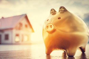 Image of a piggy bank standing in front of a luxury custom home.